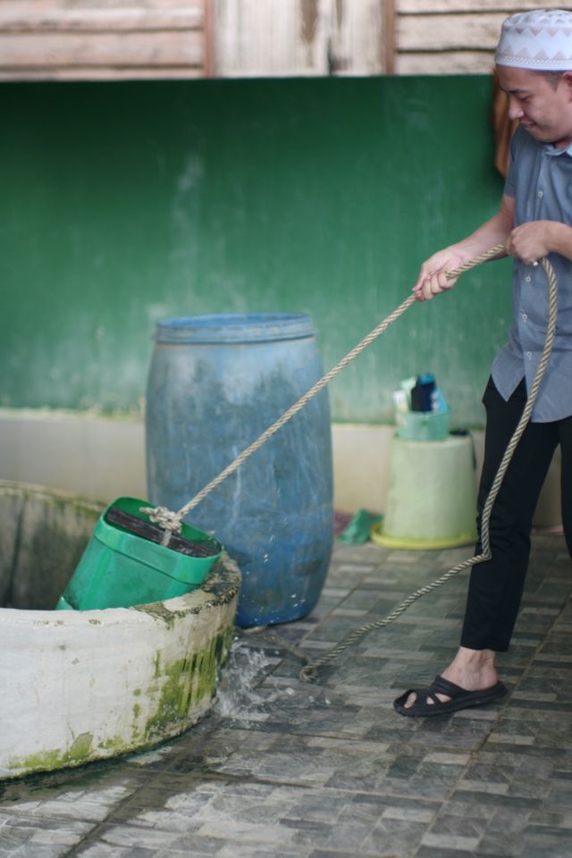 A Person removing water from waterwell